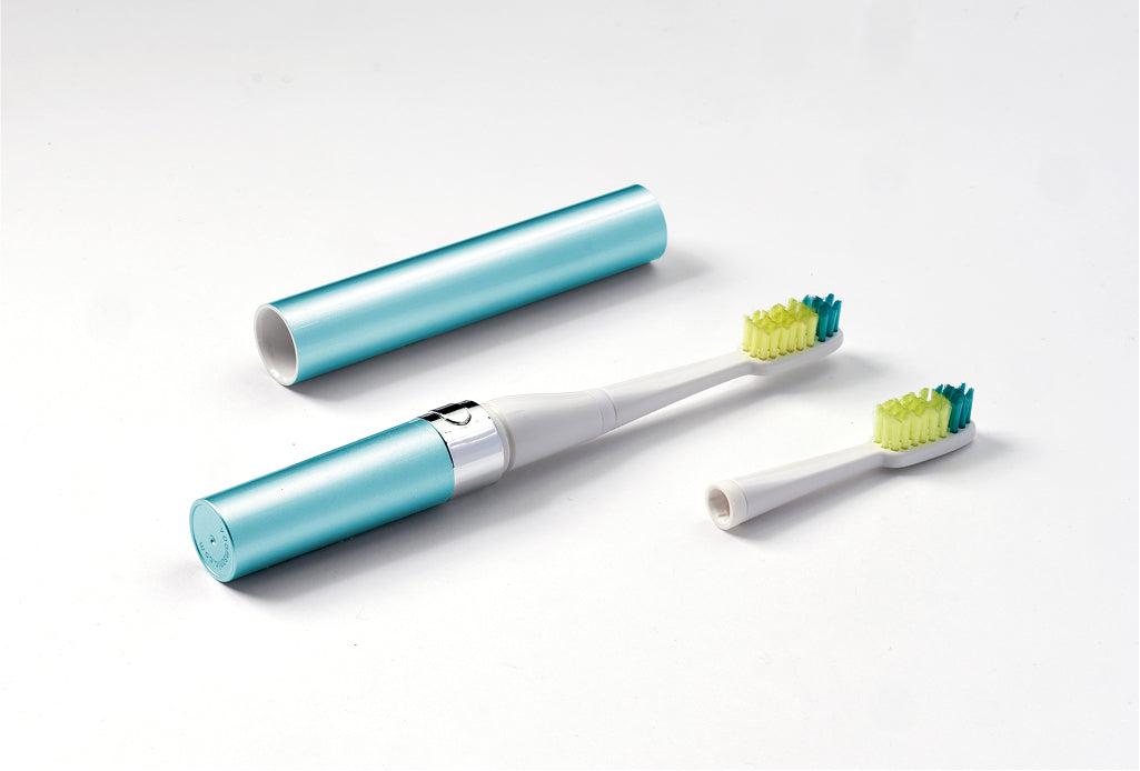 Electric toothbrush with blue handle and two brush heads on a white background