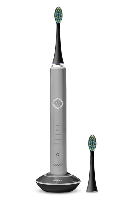 Gray electric toothbrush with black bristle head on a white background